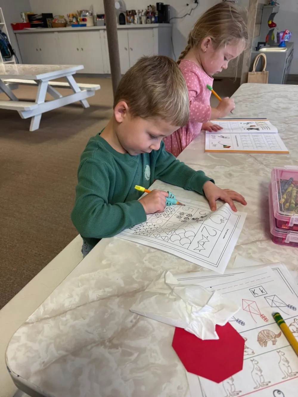 A young student coloring at Country Sunshine Preschool