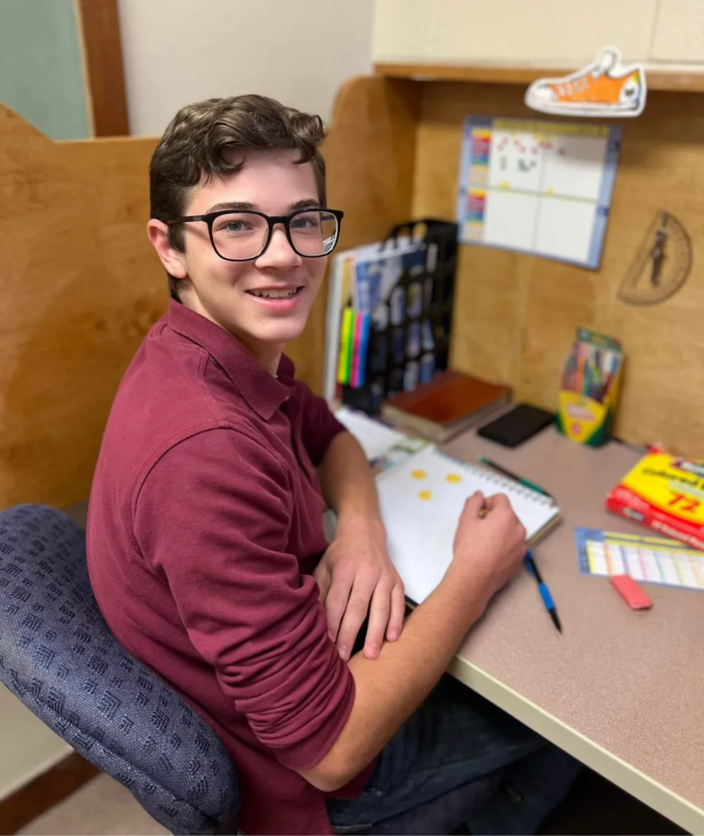 A high school student working through a PACE at his study station